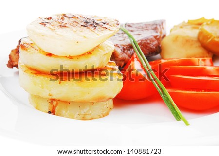 meat food : roast beef fillet steak served on white plate with tomatoes , potatoes , and chives isolated over white background