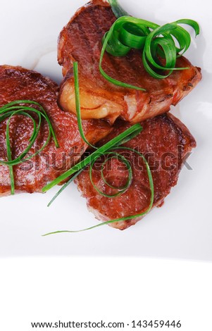 roasted beef meat strips steak on white ceramic plate isolated over white background