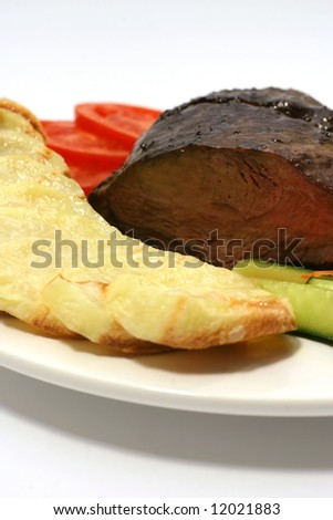 meat with potatoes and tomatoes slices on dish