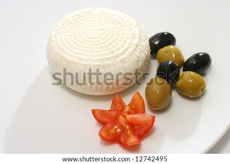 white goat cheese and olives on white dish