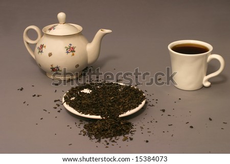 tea pot  teacup with dry green tea leafs