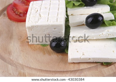 white cheese with olives and tomato on wood