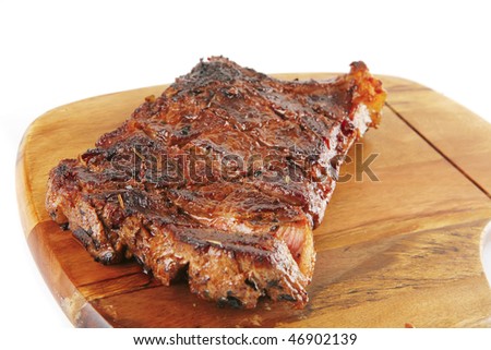 roast steak on wooden plate isolated on white