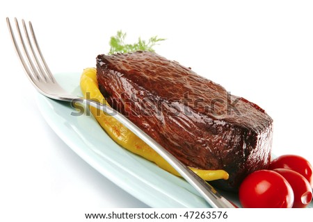 meat chunk on blue dish with knife and fork