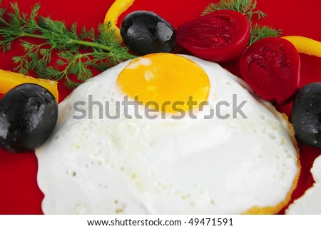 fried egg served on red dish with vegetables