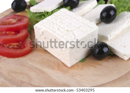 white cheese with olives and tomato on wood