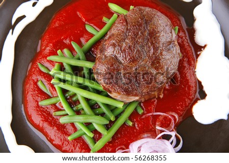 beef meat portion on red sauces over white