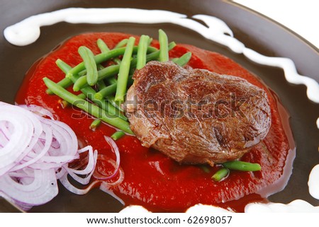 grilled beef portion on hot red sauce