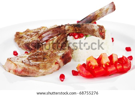 meat food: ribs on white plate with rice garnish and tomatoes over white background