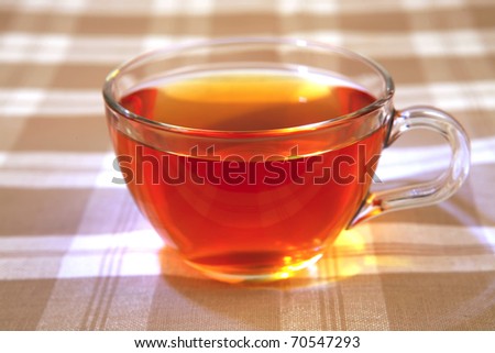 hot tea in transparent mug on tablecloth
