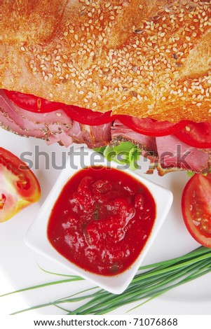 french sandwich over white plate: baguette with chicken smoked sausage and sauces isolated on white background