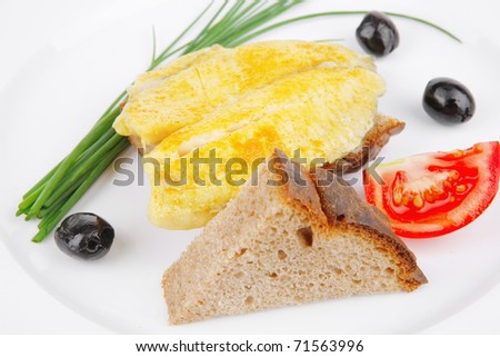 savory: fish fillet served over white plate with tomatoes,olives and bread