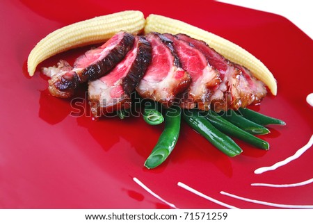 roasted beef meat with beans and corns on red plate