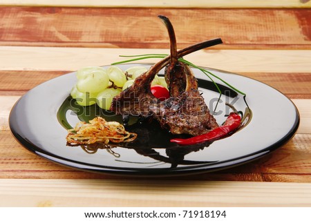 grilled ribs on black plate over wood