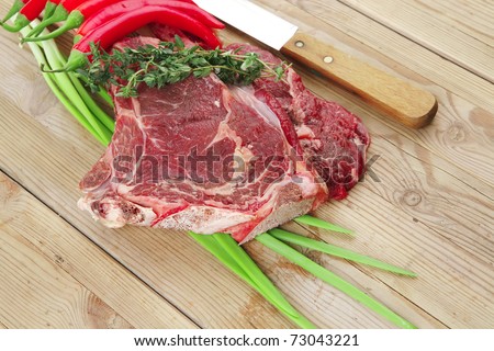 fresh spare ribs : raw lamb with thyme , red chili pepper , and green onion on wooden board