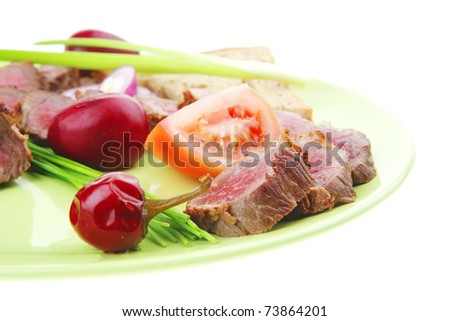 main course : roast red meat slices served on green plate with tomatoes and sprouts isolated on white background