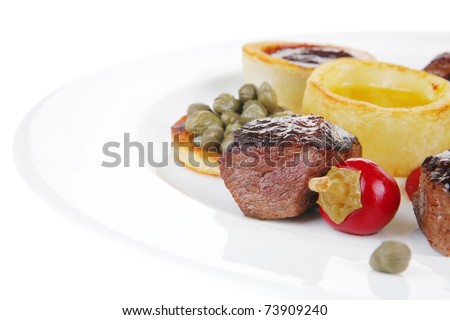european food: grilled beef meat on white china plate isolated on white background hot pepper, capers and sauces
