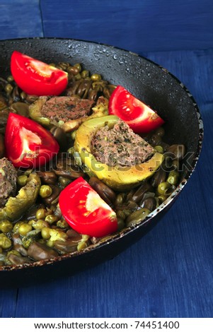 homemade cuisine: zucchini filled meat cooked with peas, beans, and tomatoes on pan