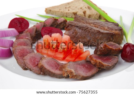 main course : roast red meat slices served on white plate with tomatoes , sprouts and bread  isolated on white background . shallow dof