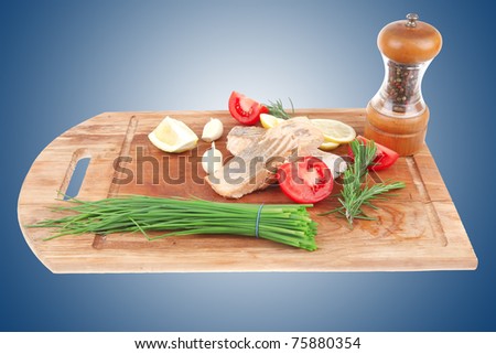healthy fish cuisine : baked pink salmon steaks with green onion, cherry tomatoes, small pepper grinder, rosemary twigs and lemon on wooden board isolated on white background