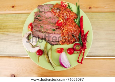 beef slices on plate over wooden table
