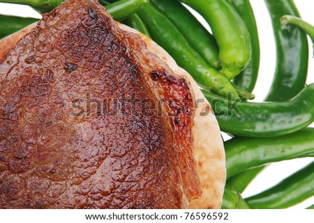 meaty food : roast meat steak on arabic pita bread over green hot chili peppers on a white background