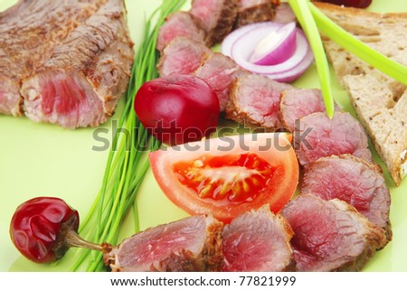 meat food : grilled fat meat served on green plate with tomatoes and sprouts isolated on white background