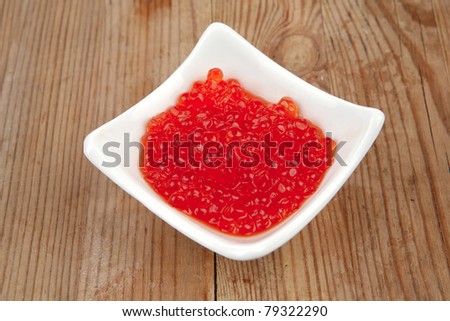 healthy food : red salmon caviar canape over wooden table in small white bowl