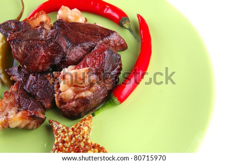 meat main course served on green plate over white