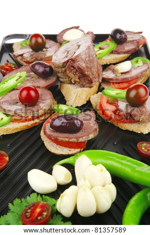 snakes on grill plate : small sandwiches with sliced meat and supplements isolated over white background