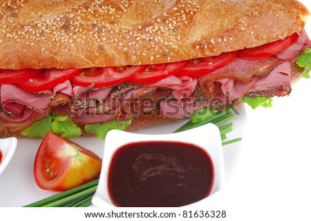 french sandwich : baguette with smoked sausage with sauces and chives isolated over white