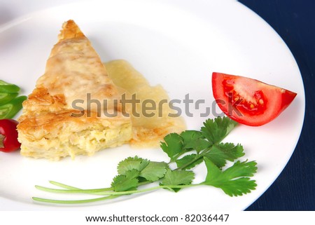 food : cheese casserole piece on white plate served with parsley and tomatoes on blue table