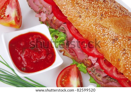french sandwich : baguette with smoked sausage with sauces and chives isolated over white