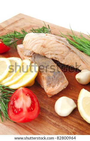healthy fish cuisine : baked pink salmon steaks with green onion, cherry tomatoes, rosemary twigs and lemon on wooden board isolated on white background