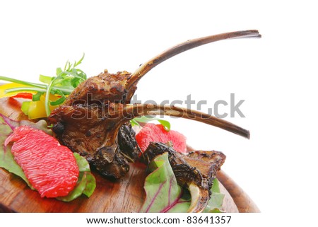 main portion : grilled ribs on woden plate isolated over white background with salad leaves and red grapefruit