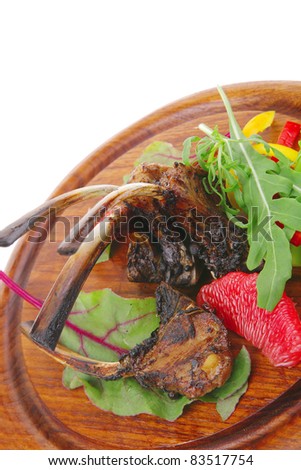 main portion : grilled ribs on woden plate isolated over white background with salad leaves and red grapefruit