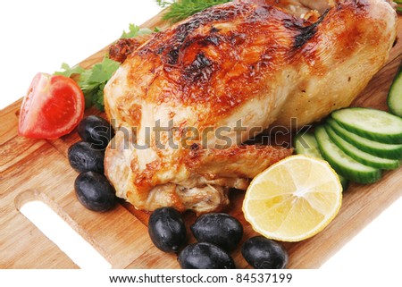 poultry : homemade roast turkey with greek olives and tomatoes on wooden board isolated over white background
