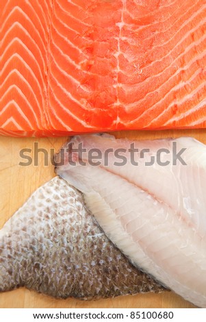 pieces of salmon , red tuna, and sole fish on wooden plate isolated on white background
