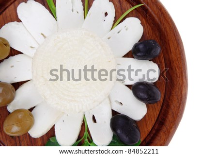 diet products : salted greek feta white cheese with olives and basil leaves sliced on wood isolated over white background