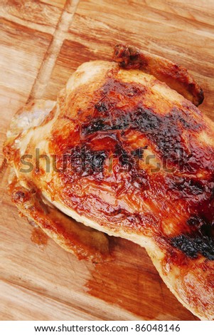 poultry : fresh grilled whole chicken on wooden cutting board isolated over white background