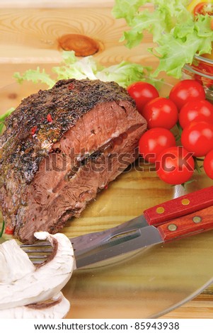 hot beef on transparent plate with salad bowl