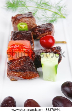 european food: roast beef meat goulash over white plate isolated on white background with vegetables