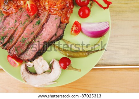beef on plate with peppers over wooden table