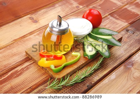 oil and vegetables served on wood cutting board