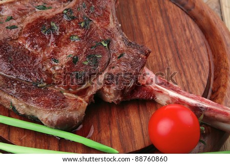 meat savory : roasted beef ribs served with green chives and cherry tomato over wood
