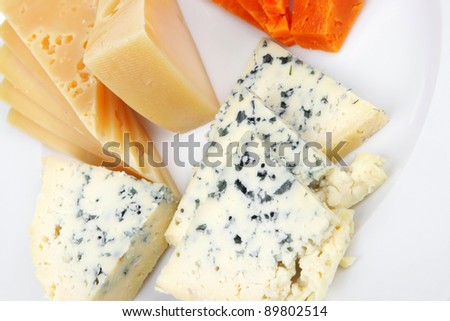 fresh aged french cheese parmesan roquefort and gruyere chops with slices on plate with isolated over white background