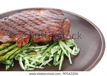 meat table : rare medium roast beef fillet with tomatoes and asparagus served on dish isolated over white