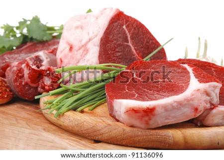 raw meat : fresh beef pork big rib and fillet with garlic and green stuff on wood isolated over white background