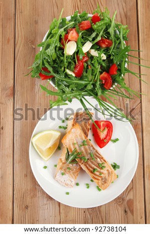 healthy sea food : roasted pink salmon fillet with vegetable salad on white dish over wooden table