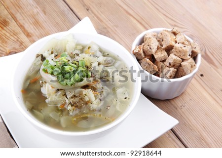 diet food : hot vegetable soup with bread  crackers in white bowl on  stand over wood table
